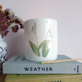 white candle pot with green and white snowdrops painting