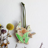 wren and snowdrop illustration printed on 3d wood and hung with green suede ribbon to display on wall