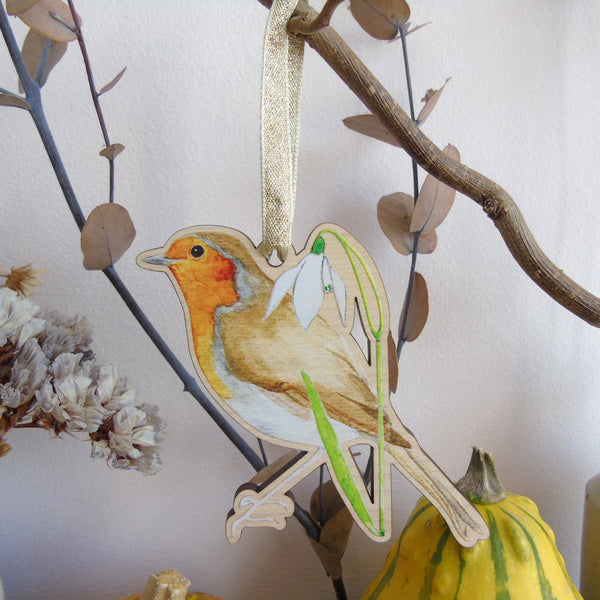 Decorative hanging ornament of a robin with a snowdrop on a branch.